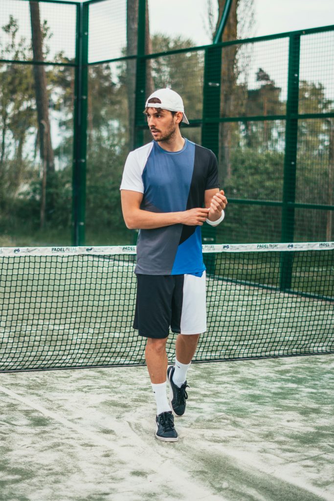 Athletic man in sportswear standing on a tennis court outdoors in Gamla Staden-Sandskogen.